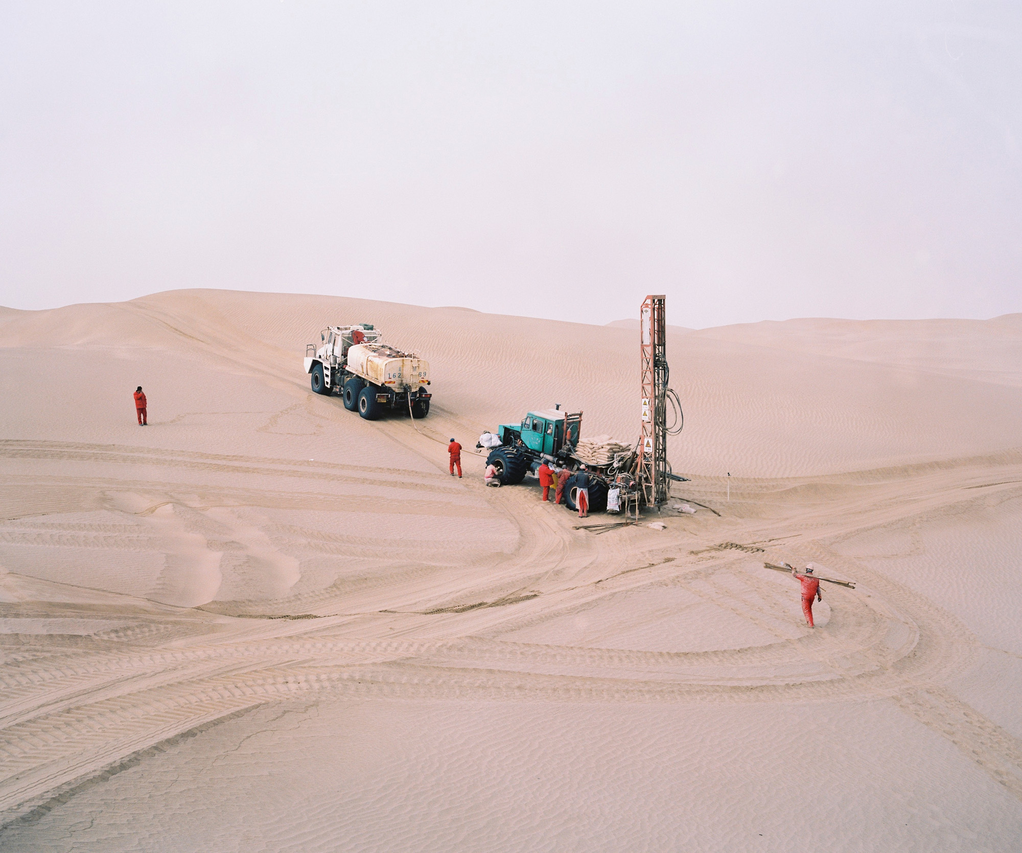 Oil exploration team from CNPC - China National Petroleum Corporation - operating in the Taklamakan desert in the province of Xinjiang. This team and a few others are setting up thousands of explosive charges for weeks at a time that are all detonated at sthe same time to detect oil fields.