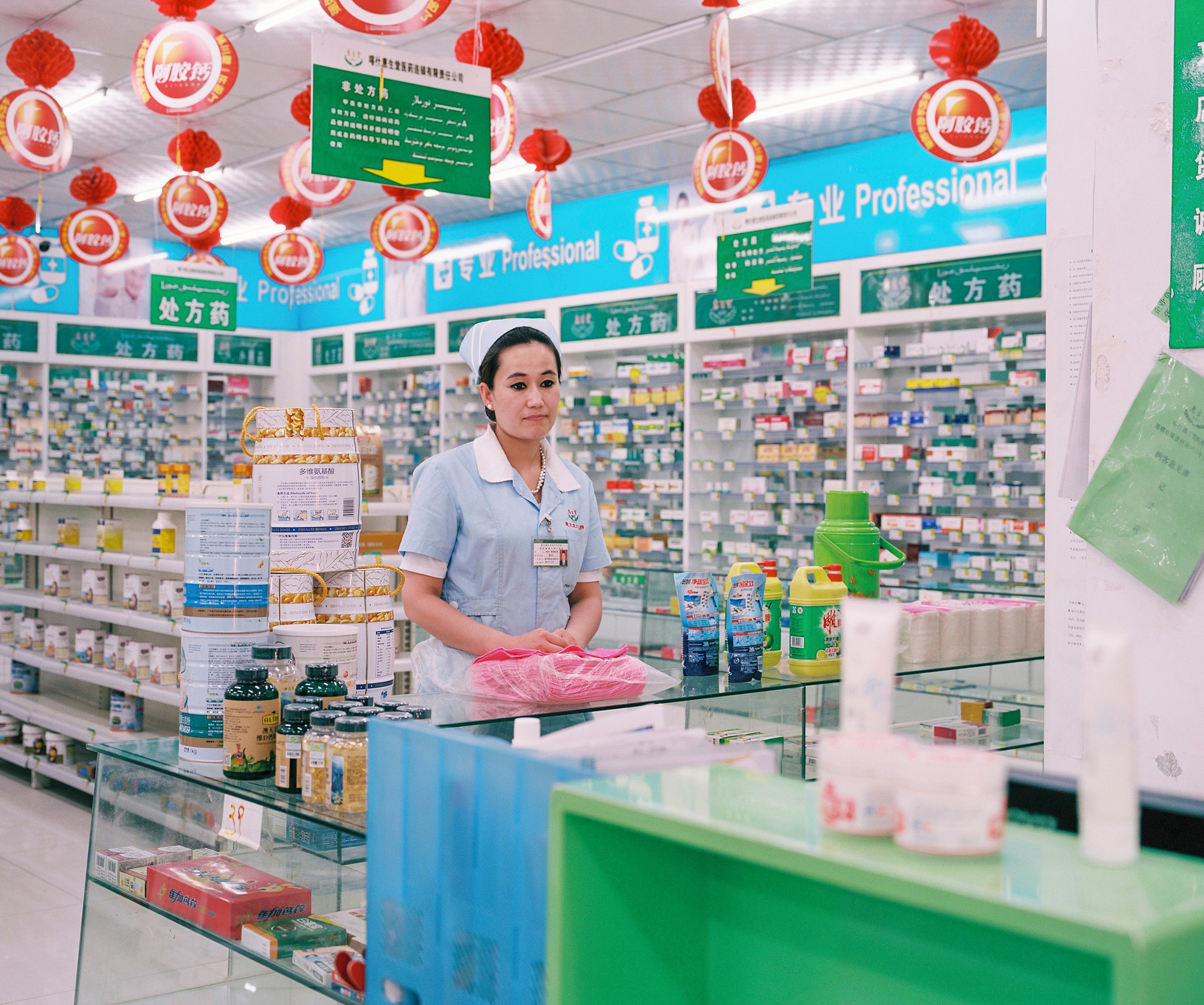 Pharmacy clerk posing in a pharmacy in Kashgar.