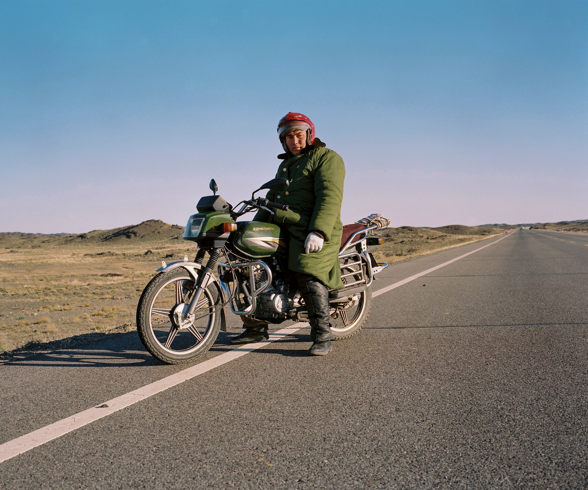 Kazakh minority Chinese rider on a road in Northern Xinjiang province at the border with Khazakhstan.